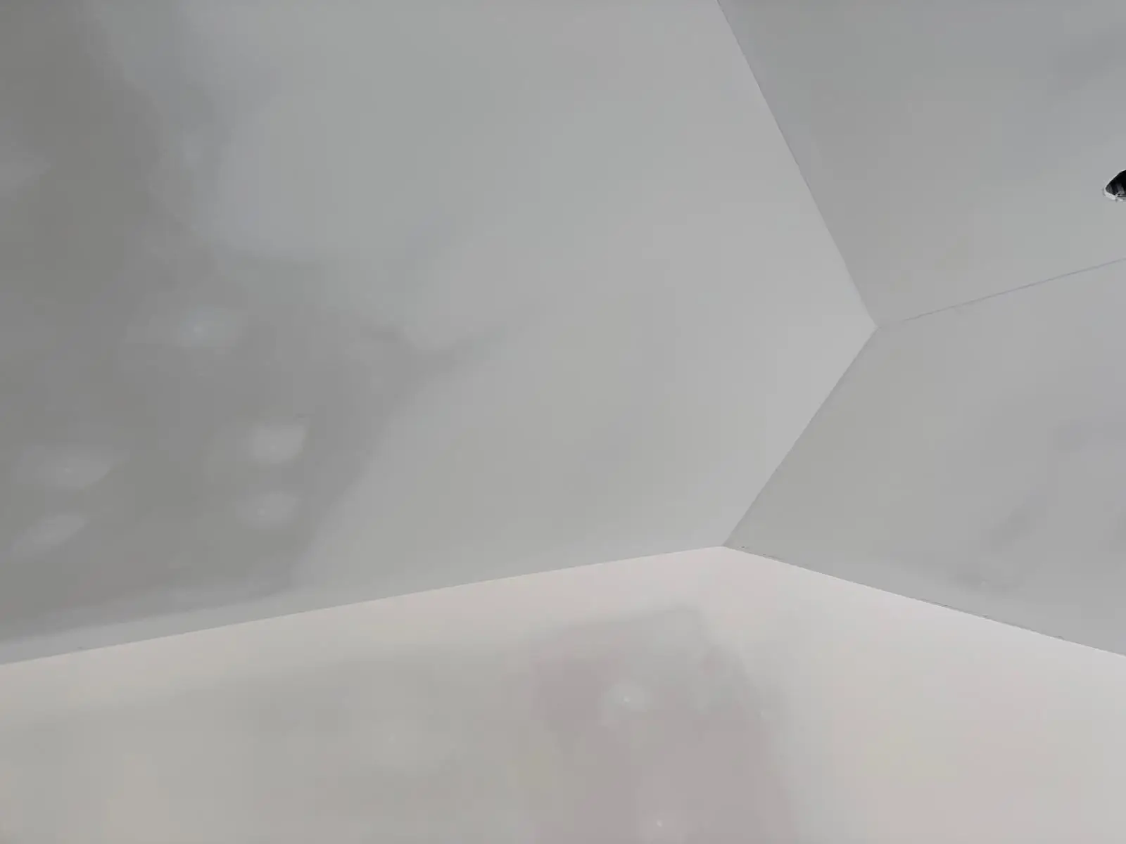 Close study of wall and ceiling planes meeting at clean arrises, light raking across the finished surface.