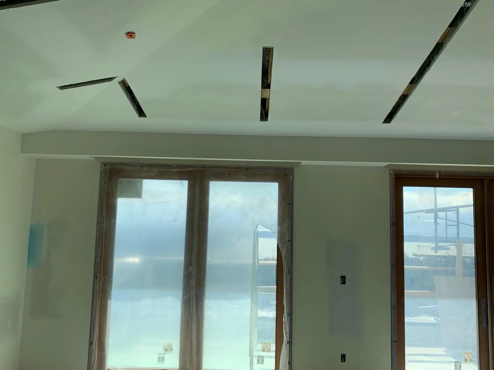 Bulkhead and slotted tray ceiling above a wall of sliding windows.