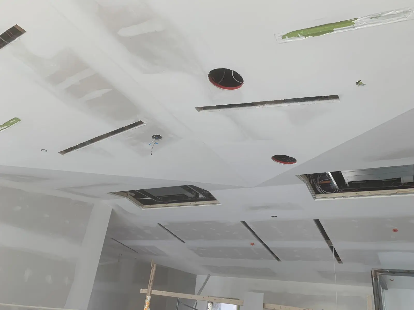 Wide ceiling coated out around linear diffusers, access panels and pot-light cutouts.