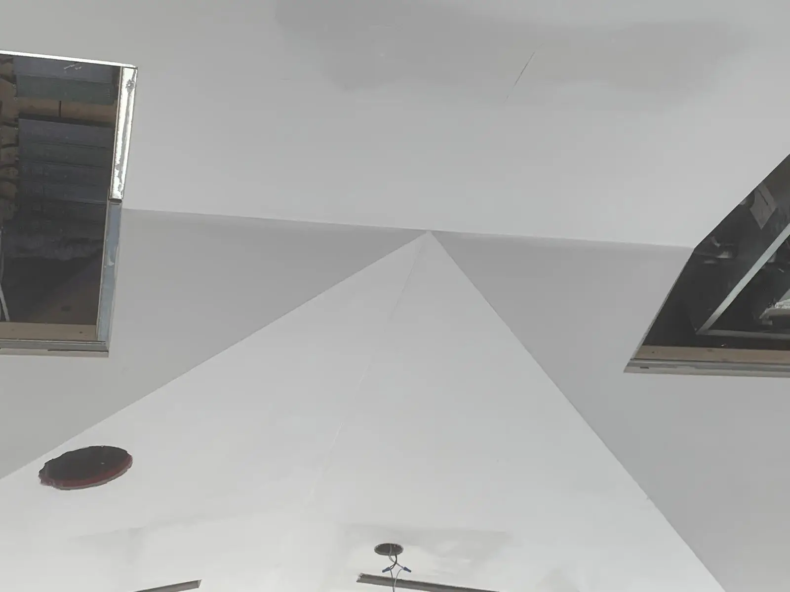 Ceiling planes converging at a clean ridge line.