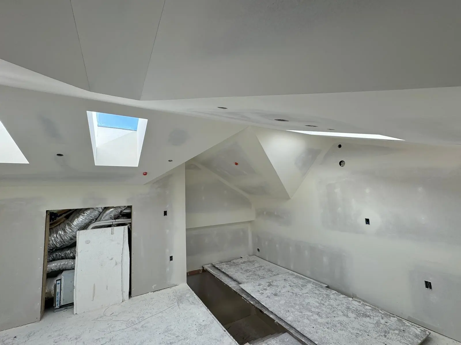Sloped ceiling with skylight returns and dormer geometry, finished.
