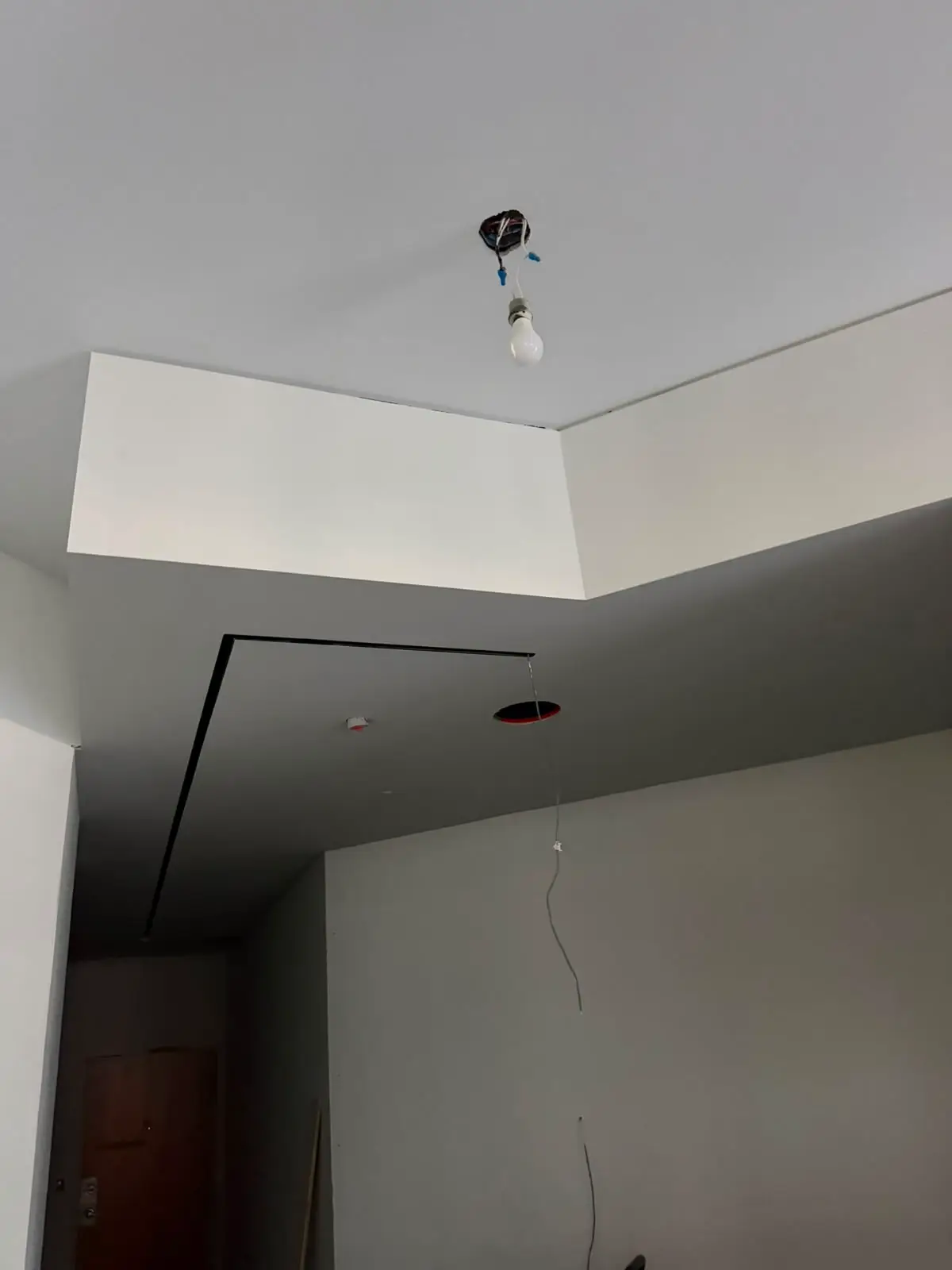 Dropped bulkhead with a shadow-line reveal over a stair landing.