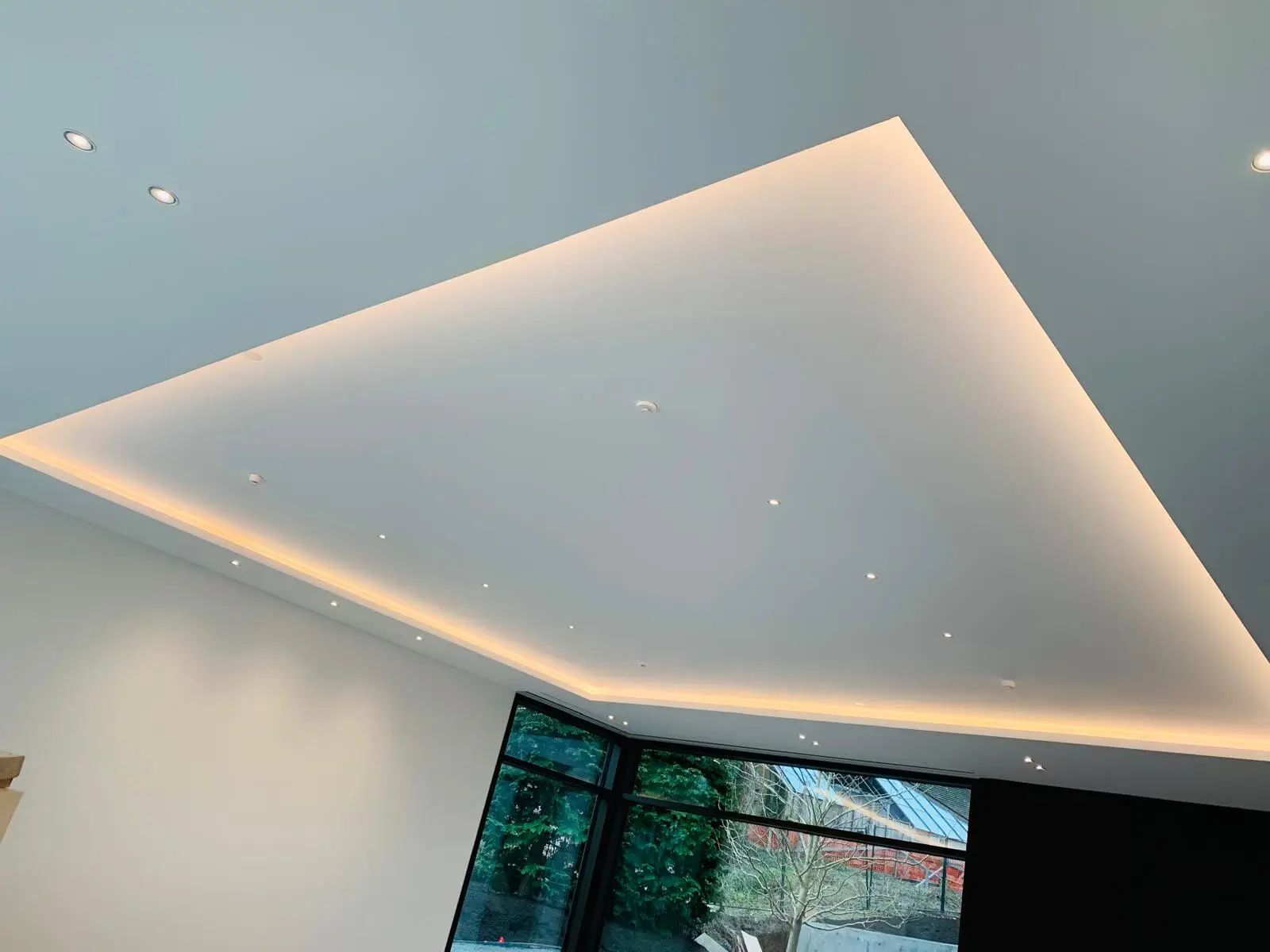 Floating rectangular ceiling raft with concealed cove lighting.