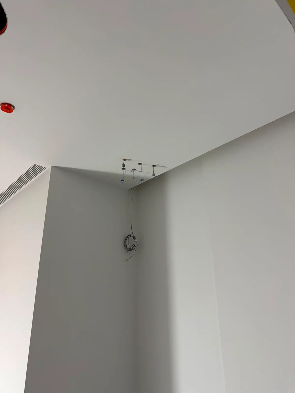 Wall and ceiling planes meeting at a sharp finished corner.