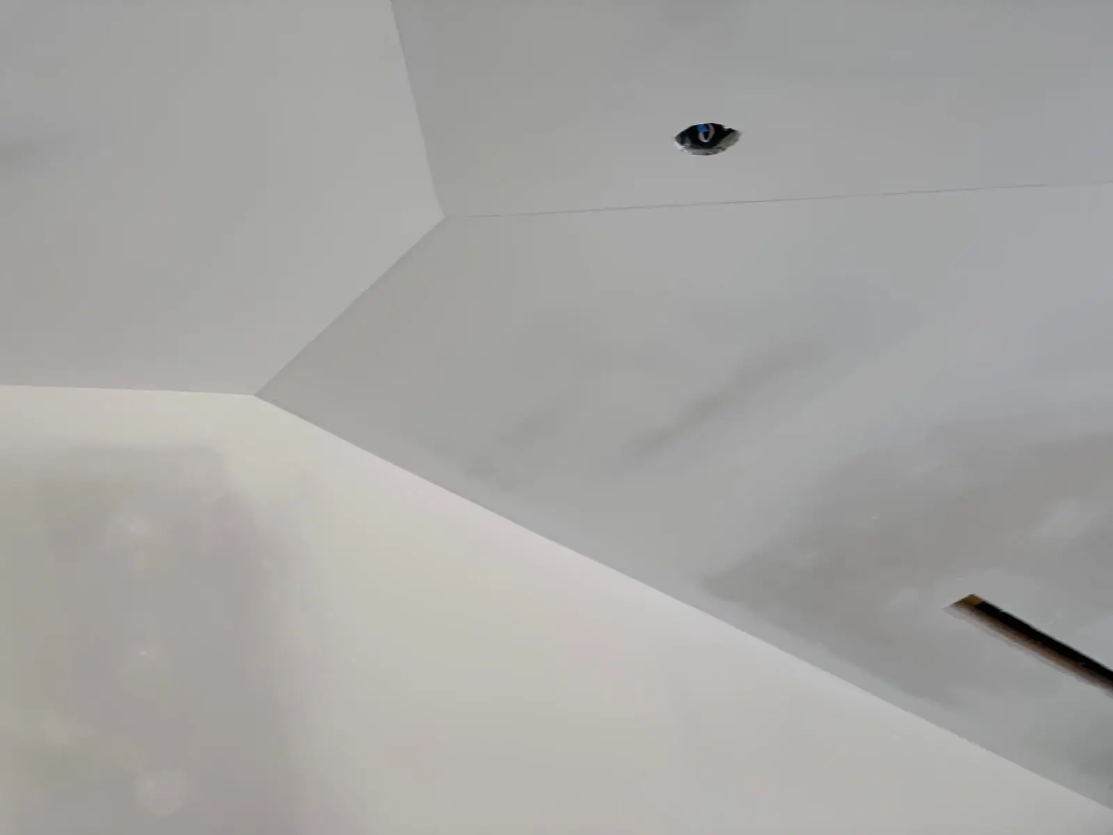 Finished ceiling planes meeting at a clean arris with light raking along the surface.